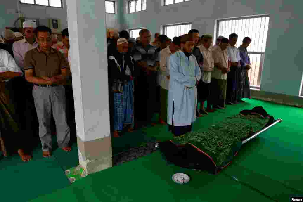 Muslims pray near the body of Soe Min, a 51-year-old man who was killed in a recent riot, at a mosque in Mandalay, Myanmar, July 3, 2014.