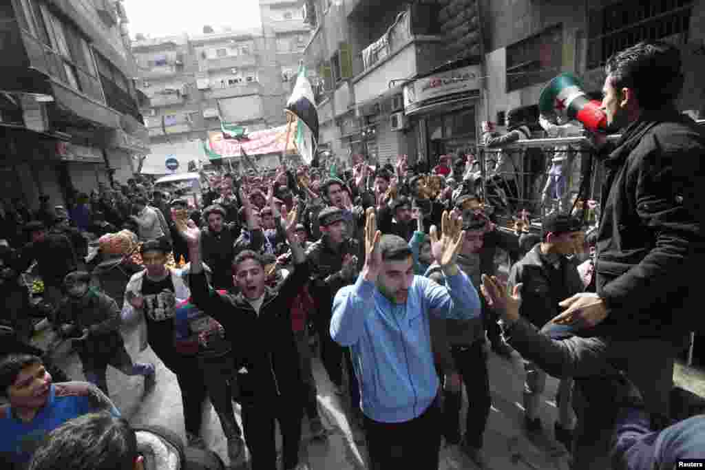 Demonstrators chant slogans and wave Syrian opposition flags during a protest against Syria's President Bashar al-Assad, Bustan al-Qasr district, Aleppo, Syria, March 1, 2013.