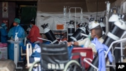 FILE - Health worker in a protective suit works in the makeshift emergency unit at Steve Biko Academic Hospital in Pretoria, South Africa, Jan. 11, 2021.