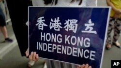 在香港警察总部前抗议的民众手持香港独立的标语。（2018年9月25日）