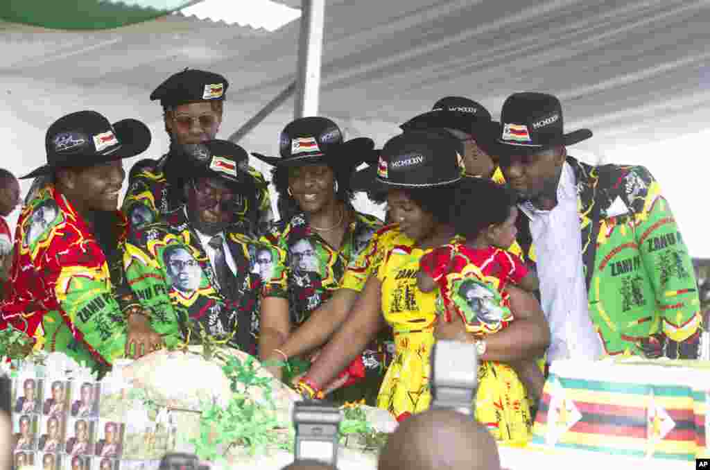 Zimbabwean President Robert Mugabe, center left, and his wife Grace, center are joined by his family as they cut the cake during his 93rd Birthday celebrations in Matopos on the outskirts of Bulawayo, Feb. 25, 2017.