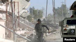 FILE - An Iraqi soldier runs through the city of Qaraqosh, as troops search for any Islamic State militants still in the area, near Mosul in Iraq October 30, 2016. 