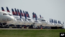 FILE - Several dozen mothballed Delta Air Lines jets are parked at Kansas City International Airport in Kansas City, Mo., April 1, 2020.