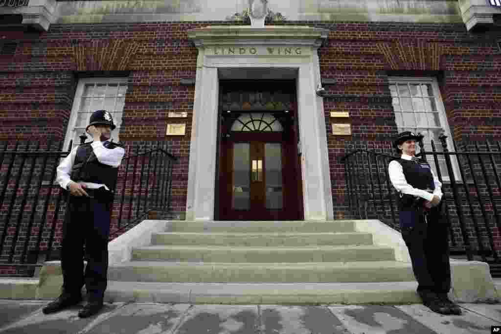 Polisi Inggris menjaga pintu masuk sayap Lindo di Rumah Sakit St. Mary's di London (22/7). (AP/Lefteris Pitarakis)
