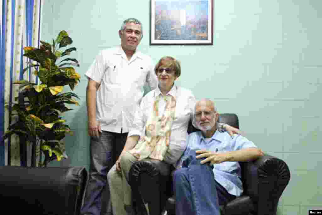 លោក Alan Gross (រូបស្តាំ) ដែលជាបុគ្គលិករបស់ភ្នាក់ងារស.រ.អាសម្រាប់ការអភិវឌ្ឃអន្តរជាតិ ហើយដែលបានជាប់ពន្ធនាគារបង្ហាញរូបថតមួយកំឡុងពេលទស្សនៈកិច្ចជាមួយមេដឹកនាំសហគមន៏ជ្វីហ្វរបស់ប្រទេសគុយបា លោកស្រី Adela Dworin និងលោក David Prinstein អនុប្រធានមន្ទីរពេទ្យ Carlos J. Finlay Military Hospital នៅទីក្រុងឡាហាវ៉ាន កាលពីថ្ងៃទី២៨ ខែកញ្ញា ឆ្នាំ២០១២។ 