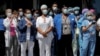 Trabajadores de la salud se reúnen para un almuerzo ofrecido por miembros del Departamento de Policía de la Ciudad de Nueva York (NYPD) fuera del Hospital de Brooklyn.