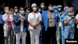 Trabajadores de la salud se reúnen para un almuerzo ofrecido por miembros del Departamento de Policía de la Ciudad de Nueva York (NYPD) fuera del Hospital de Brooklyn.