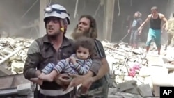 Trabajadores de defensa civil rescataron a niños después de los ataques aéreos en Alepo, Siria, el jueves, 28 de abril de 2016.