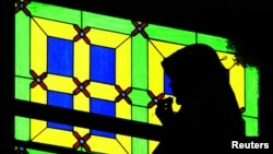 FILE - A Malaysian Muslim woman recites a prayer at a mosque in Kuala Lumpur.