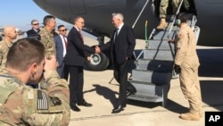 Sekretar odbrane SAD Džim Matis, u centru, pozdravlja se sa američkim ambasadorom Daglasom Silimenom po dolasku na bagdaški međunarodni aerodrom, u nenajavljenu posetu, 20. februrara 2017. (AP Photo/Lolita Baldor)