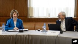 Kepala urusan kebijakan luar negeri Uni Eropa Catherine Ashton (kiri) bersama Menlu Iran Javad Zarif sesaat sebelum dimulainya dialog nuklir di Jenewa (15/10).