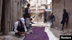 Free Syrian Army fighters prepare curtains to be erected as cover from snipers loyal to Syria's President Bashar al-Assad, Babeela area of suburban Damascus, March 30, 2013.