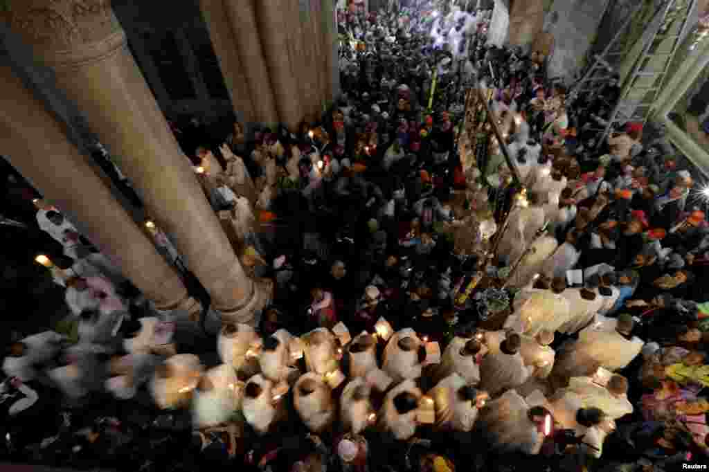 Members of the Catholic clergy hold candles during Easter procession in the Church of the Holy Sepulchre in Jerusalem's Old City, April 5, 2015.