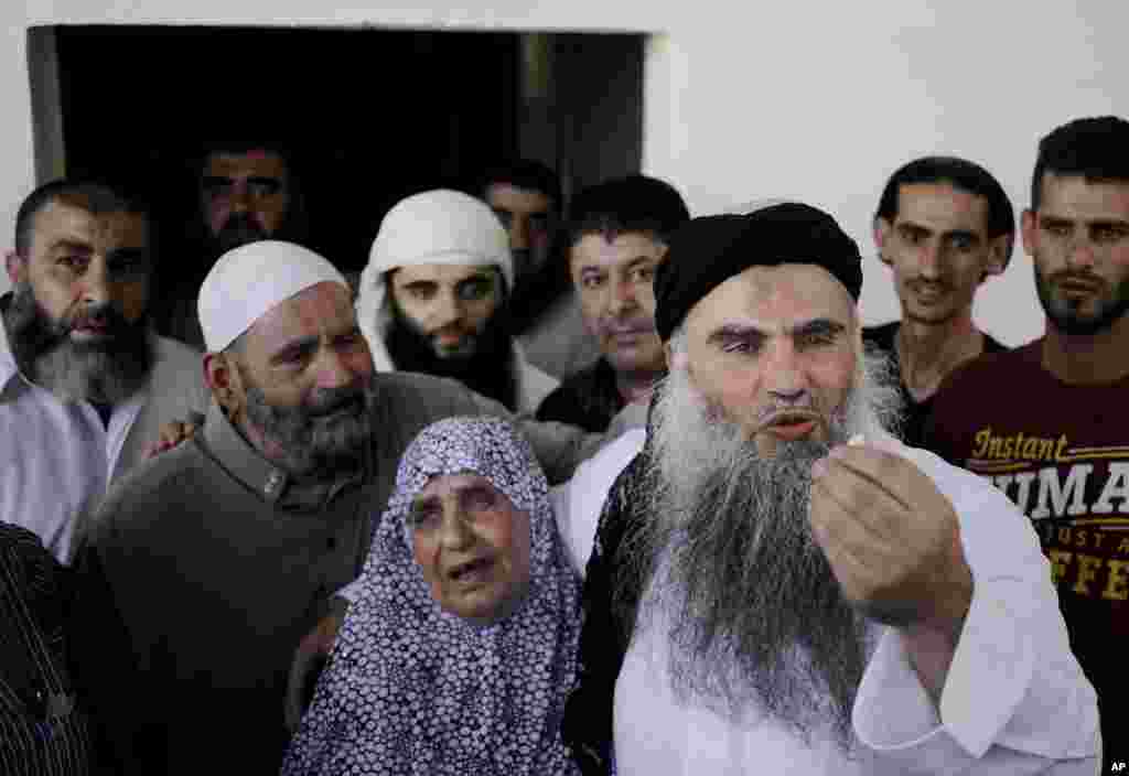 Abu Qatada stands with his mother Aisha as he speaks to the media from his parents' home in Amman, Jordan, Sept. 24, 2014.