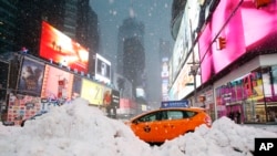 Un taxista pasa entre una montaña de nieve acumulada en Time Square, en la ciudad de Nueva York, el martes, 14 de marzo, de 2017.