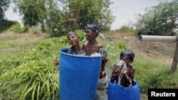 Enfriandose con agua en las afueras de Ahmedabad, India, donde cientos han muerto de calor.