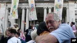 Para kerabat dari korban kejahatan manusia berpelukan setelah hakim memutuskan mantan pejabat polisi bersalah melakukan kejahatan kemanusiaan pada masa diktator 1976–1983 di La Plata, Argentina, Selasa, 26 Maret 2024. (Foto: Gustavo Garello/AP Photo)