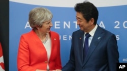 នាយករដ្ឋមន្រ្តីអង់គ្លេស Theresa May និងនាយករដ្ឋមន្រ្តីជប៉ុន Shinzo Abe ចាប់ដៃមុននឹងជំនួបទ្វេភាគី G20 កាលពីថ្ងៃទី០១ ធ្នូ ២០១៨។

