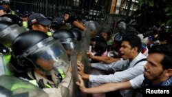 Opposition supporters confront riot security forces while rallying against President Nicolas Maduro in Caracas, Venezuela, May 12, 2017. 