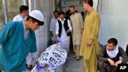 Staf rumah sakit dan kerabat mengangkut jenazah seorang petugas polisi di sebuah rumah sakit, di Quetta, Pakistan Selasa, 1 Agustus 2023. Orang-orang bersenjata dengan sepeda motor melepaskan tembakan ke arah polisi yang mengawal tim pekerja polio. (Foto: AP)