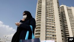 A pedestrian wearing a face mask crosses a street in northern Tehran, Iran, March 1, 2020.