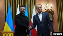 Presiden Ukraina Volodymyr Zelenskiy dan Perdana Menteri Polandia Donald Tusk berjabat tangan saat bertemu di Kantor Perdana Menteri di Warsawa, Polandia, 15 Januari 2025. (Aleksandra Szmigiel/REUTERS)