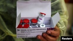 Un trabajador de la salud sostiene una caja con vacunas contra el COVID-19 fabricadas por el Reino Unido durante una jornada de vacunación en Israel.