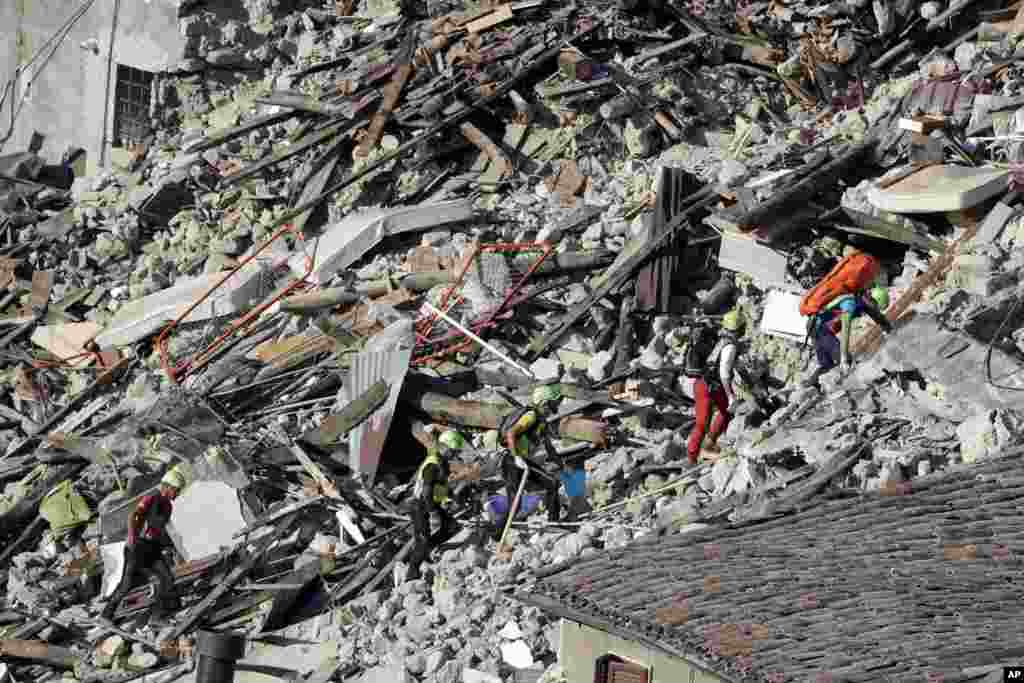 Rescuers make their way through destroyed houses following an earthquake in Pescara Del Tronto, central Italy, Aug. 25, 2016.