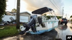 Sebuah perahu terhempas di jalan akibat banjir yang dipicu Badai Helene di Hudson, Florida, 27 September 2024.