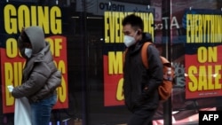 FILE - Sale and going-out-of-business signs are displayed in a store window in the Brooklyn borough of New York City, Dec. 1, 2020. 