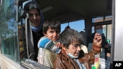 Dua anak laki-laki Yazidi, yang menderita infeksi setelah ditahan oleh kelompok Negara Islam (ISIS) menunggu bersama ibunya dalam bus yang akan pergi ke kota Kurdi, Dohuk di Irak. (Foto: Ilustrasi)