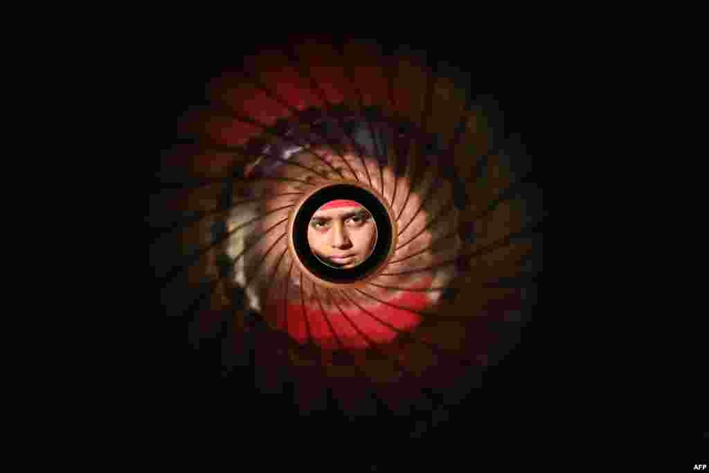 A student looks through an army anti-tank rocket launcher during the "Weapon and Equipment Display" exhibition organized by the Indian Army as part of "Vijay Diwas" celebrations, at the Punjab State War Heroes Memorial and Museum in Amritsar. 