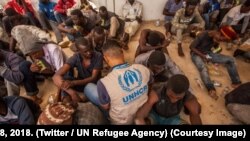 Un agent du HCR au milieu de migrants en Libye, 8 septembre 2018. (Twitter/UN Refugee Agency)