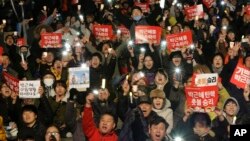 Protesters shout slogans during a rally calling for impeached President Park Geun-hye's arrest in Seoul, South Korea, March 10, 2017. The signs read "Park Geun-hye's arrest." (AP Photo/Ahn Young-joon)