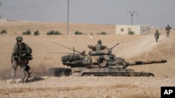 Turkish tanks and troops stationed near Syrian town of Manbij, Syria, Oct. 15, 2019. Russia moved to fill the void left by the United States in northern Syria on Tuesday, deploying troops to keep apart advancing Syrian government and Turkish forces.