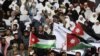 Protesters from opposition parties hold flags and signs during a demonstration against the government's decision to lift fuel subsidies, in Amman, Jordan, November 19, 2012.