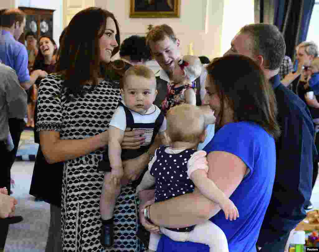 Britain's Catherine, Duchess of Cambridge, holds her son Prince George as she talks to other parents at a Plunket play group event at Government House in Wellington, New Zealand.