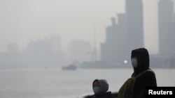 FILE - People wear protective masks near the Bund during a polluted day in Shanghai, China, Jan. 19, 2016. Environmentalists have warned that dirty water is a greater problem than dirty air.
