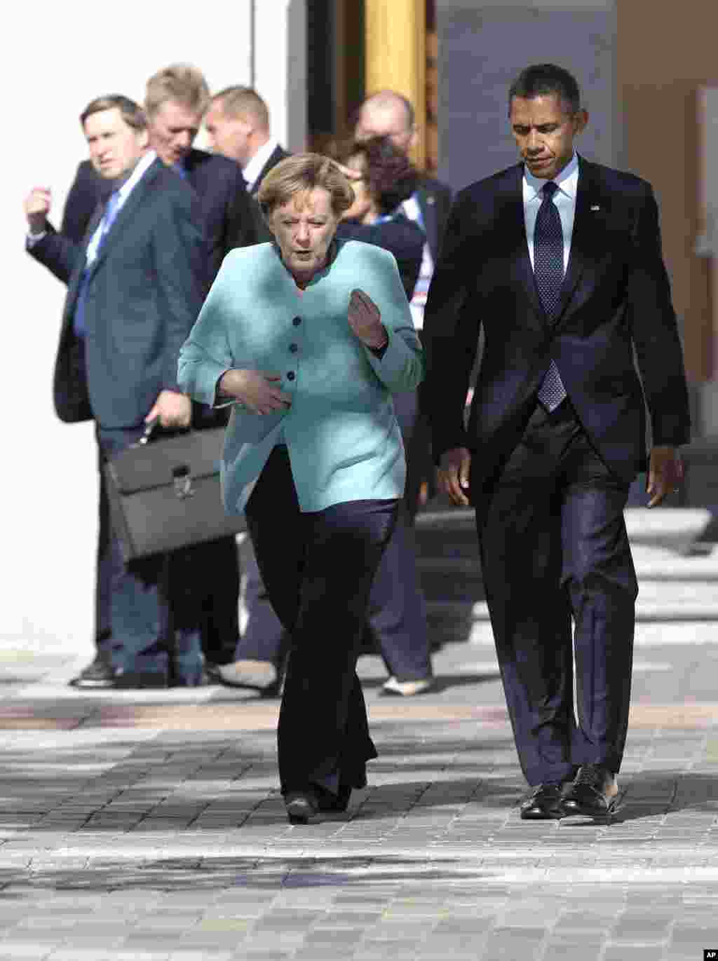 U.S. President Barack Obama, right, walks with Germany's Chancellor Angela Merkel prior to a group photo of G-20 leaders outside of the Konstantin Palace in St. Petersburg, Russia, Sept. 6, 2013. 