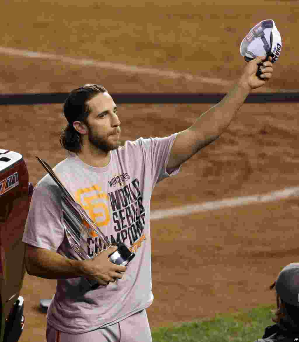 San Francisco Giants pitcher Madison Bumgarner celebrates winning the series and earning the Most Valuable Player trophy after Game 7 of baseball's World Series against the Kansas City Royals, Kansas City, Missouri, Oct. 29, 2014.