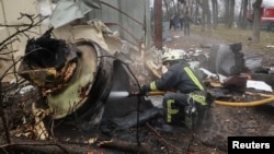A firefighter extinguishes the remains of a missile, which Ukrainian authorities and other investigators said was made in North Korea, at the site of a Russian strike in Kharkiv on Jan. 2, 2024.