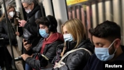 Sejumlah warga mengenakan masker saat bepergian dengan kereta bawah tanah di tengah perebakan COVID-19 di Barcelona, Spanyol, pada 12 Januari 2022. (Foto: Reuters/Nacho Doce)