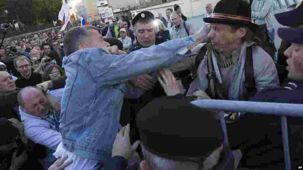 Pro and anti demonstrators clash during an anti-war rally and march in downtown Moscow, Russia, Sept. 21, 2014.