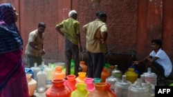 Warga antre dekat wadah-wadah plastik yang berisi air minum di tempat pendistribusian air di Chennai, 19 Juni 2019. Debit air di empat bendungan di Chennai sudah turun ke salah satu titik terendah dalam 70 tahun.