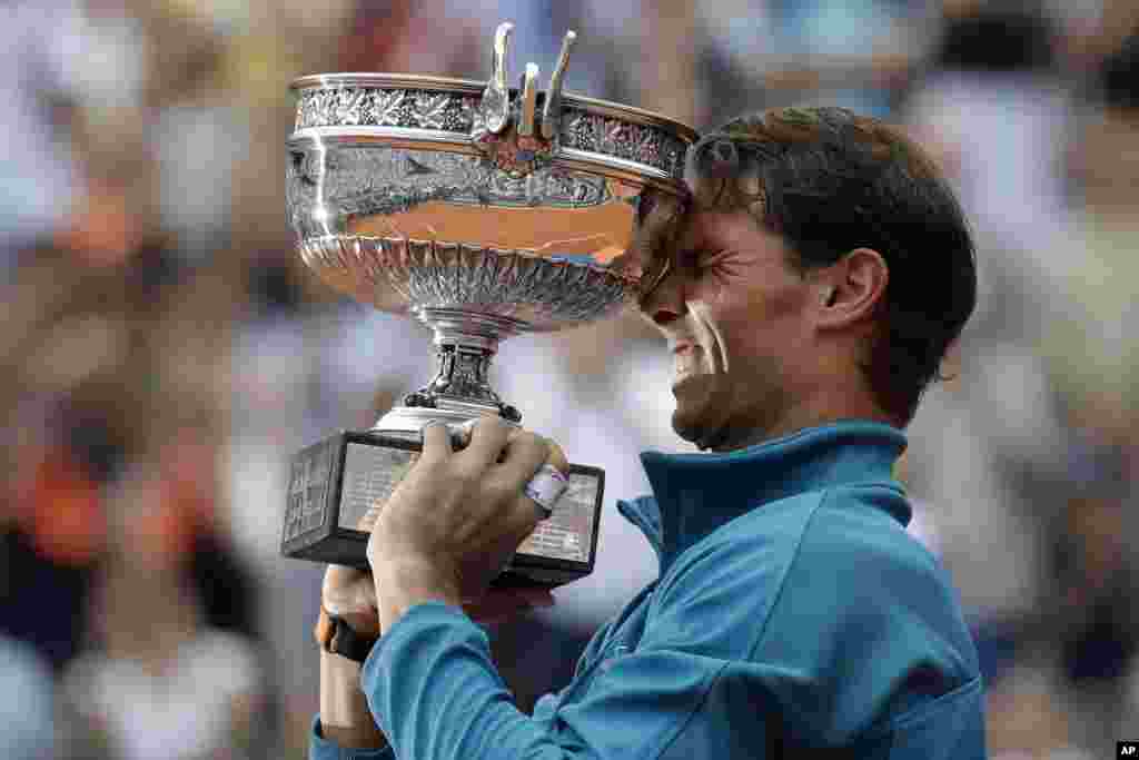 Spain's Rafael Nadal holds the trophy as he celebrates winning the men's final match of the French Open tennis tournament against Austria's Dominic Thiem in three sets 6-4, 6-3, 6-2, at the Roland Garros stadium in Paris, France.