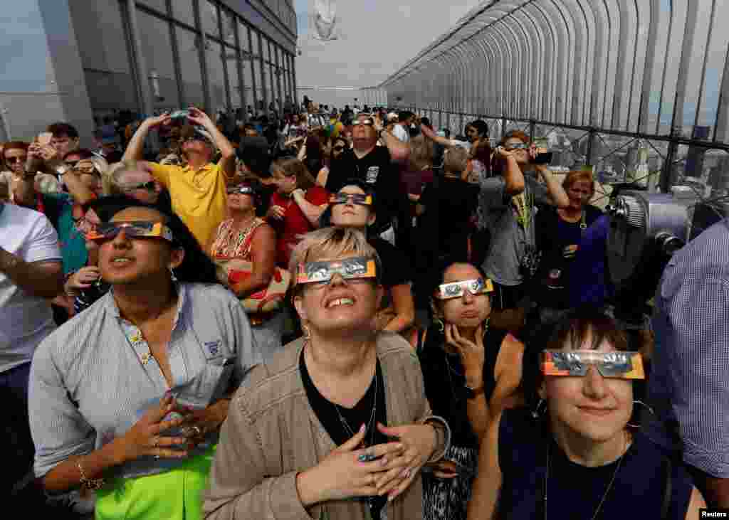 People watch the solar eclipse from the observation deck of The Empire State Building in New York City, August 21, 2017.