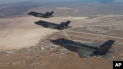 Three F-35 Joint Strike Fighters fly over Edwards Air Force Base in this Dec. 10, 2011 handout photo provided by Lockheed Martin.