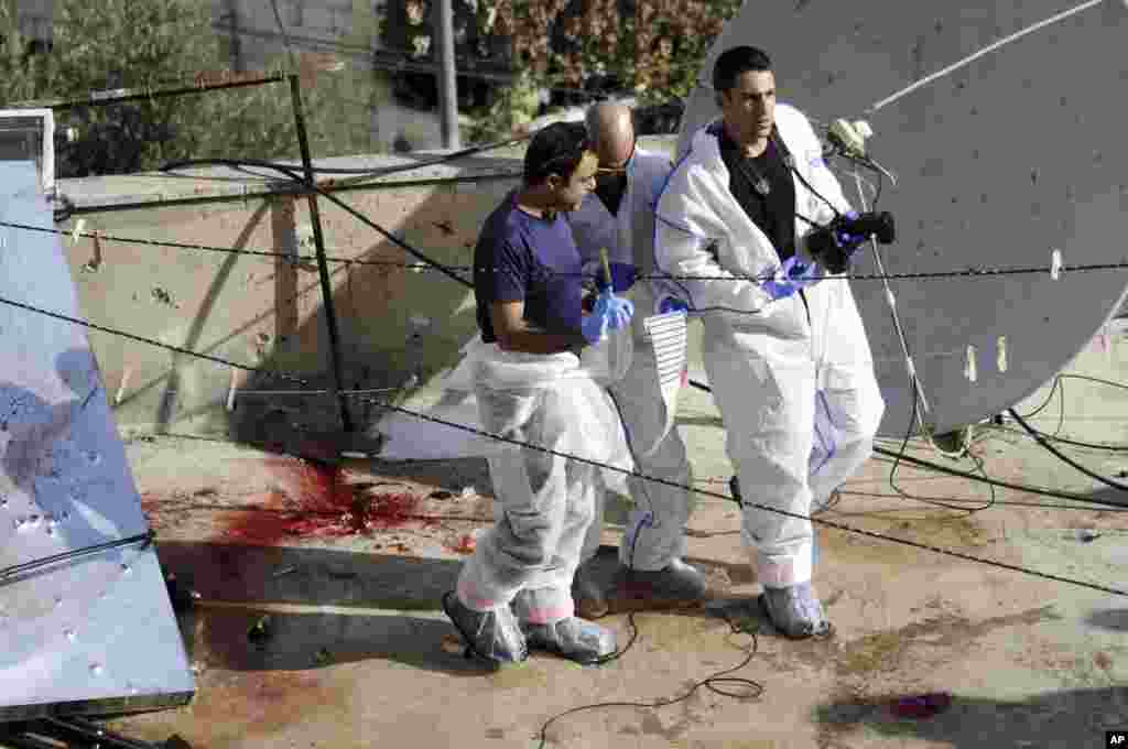 Forensics inspect the scene where Moatez Higazi was shot on the roof of his house in east Jerusalem, Oct. 30, 2014.