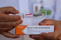 Dr. Gustavo Romero, of University Hospital of Brasilia’s Nucleus of Tropical Medicine, presents to the press China’s Sinovac Biotech vaccine for the new coronavirus before it is administered, Aug. 5, 2020.