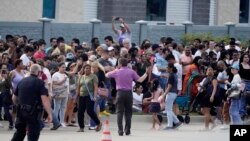 La gente se reúne frente a un centro comercial después de un tiroteo el sábado 6 de mayo de 2023 en Allen, Texas.